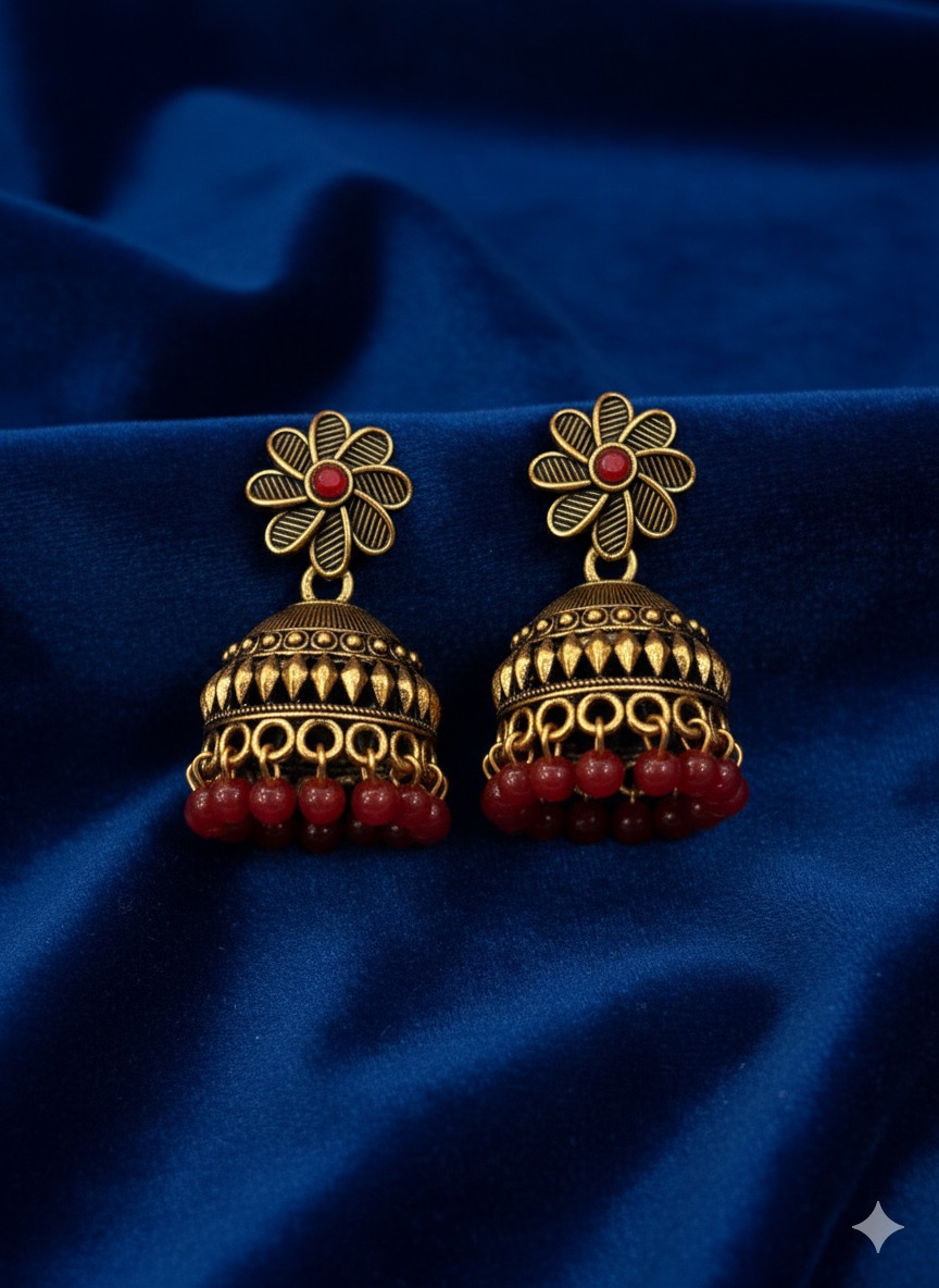 Antique Gold-Plated Jhumka Earrings with Red Stone and Bead Embellishments.