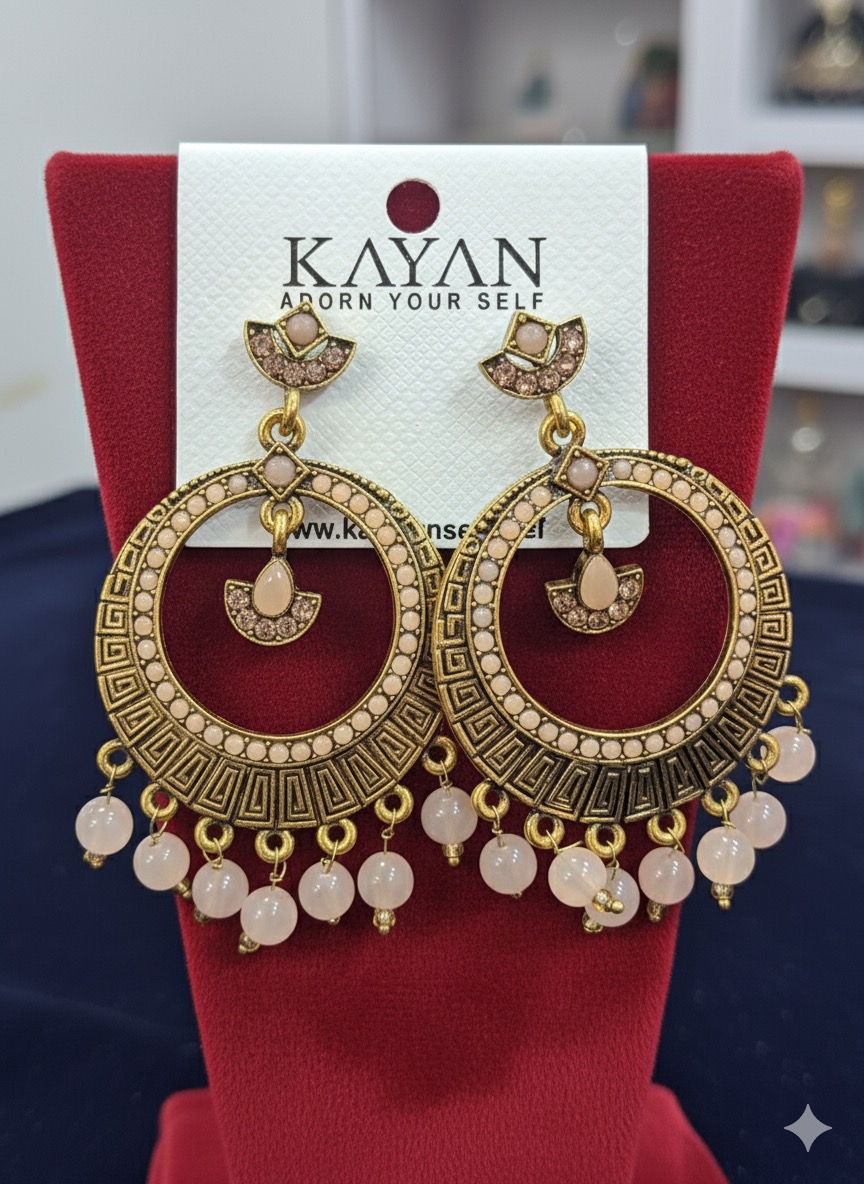 These are a pair of statement earrings with a distinct ethnic or bohemian flair, featuring an antique gold-tone finish.